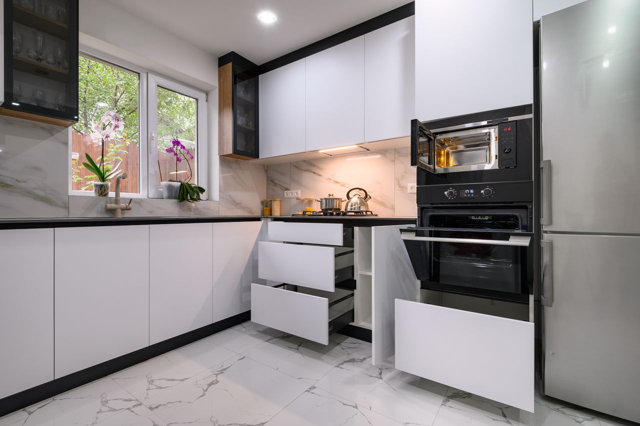Bright white refaced kitchen with marble backsplash, organized drawers and natural light