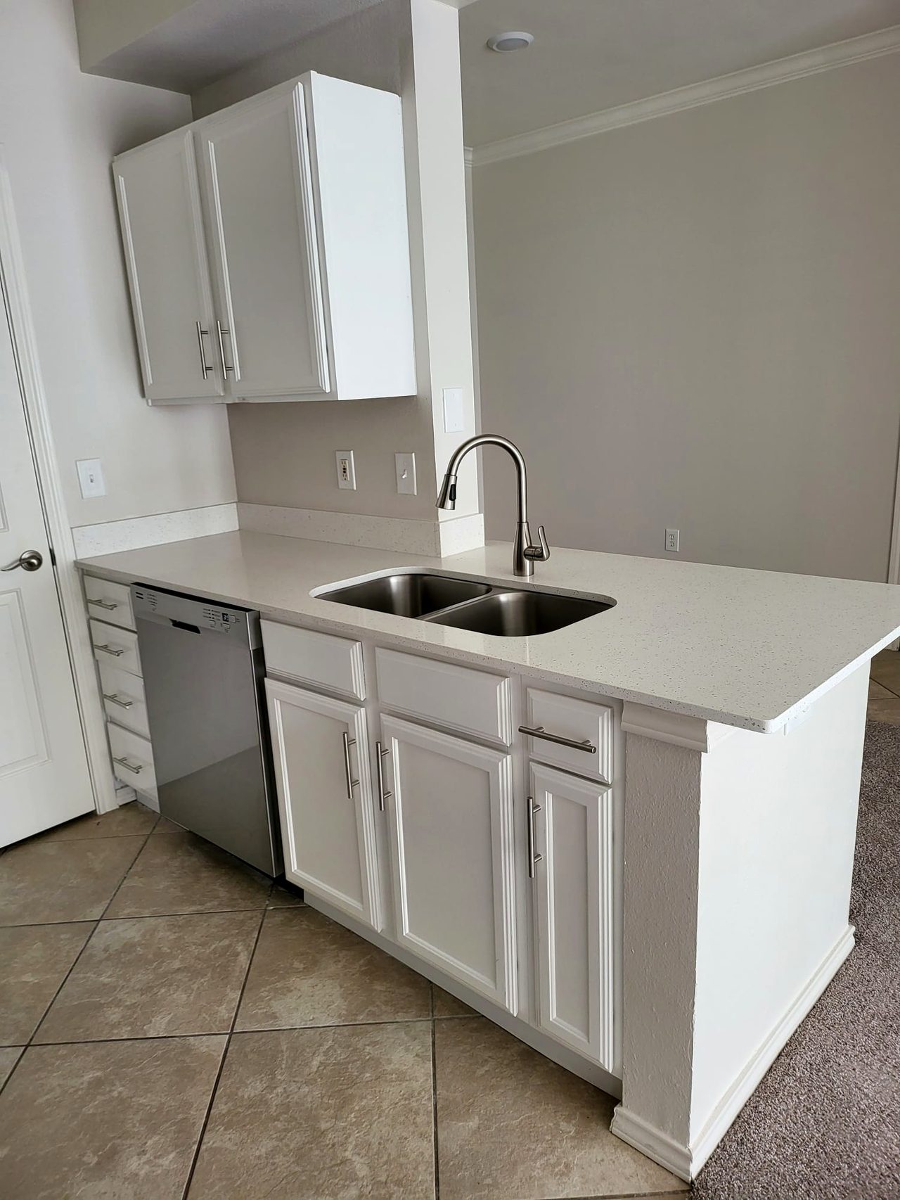 Kitchen after — white refaced cabinets, quartz counters and stainless appliances