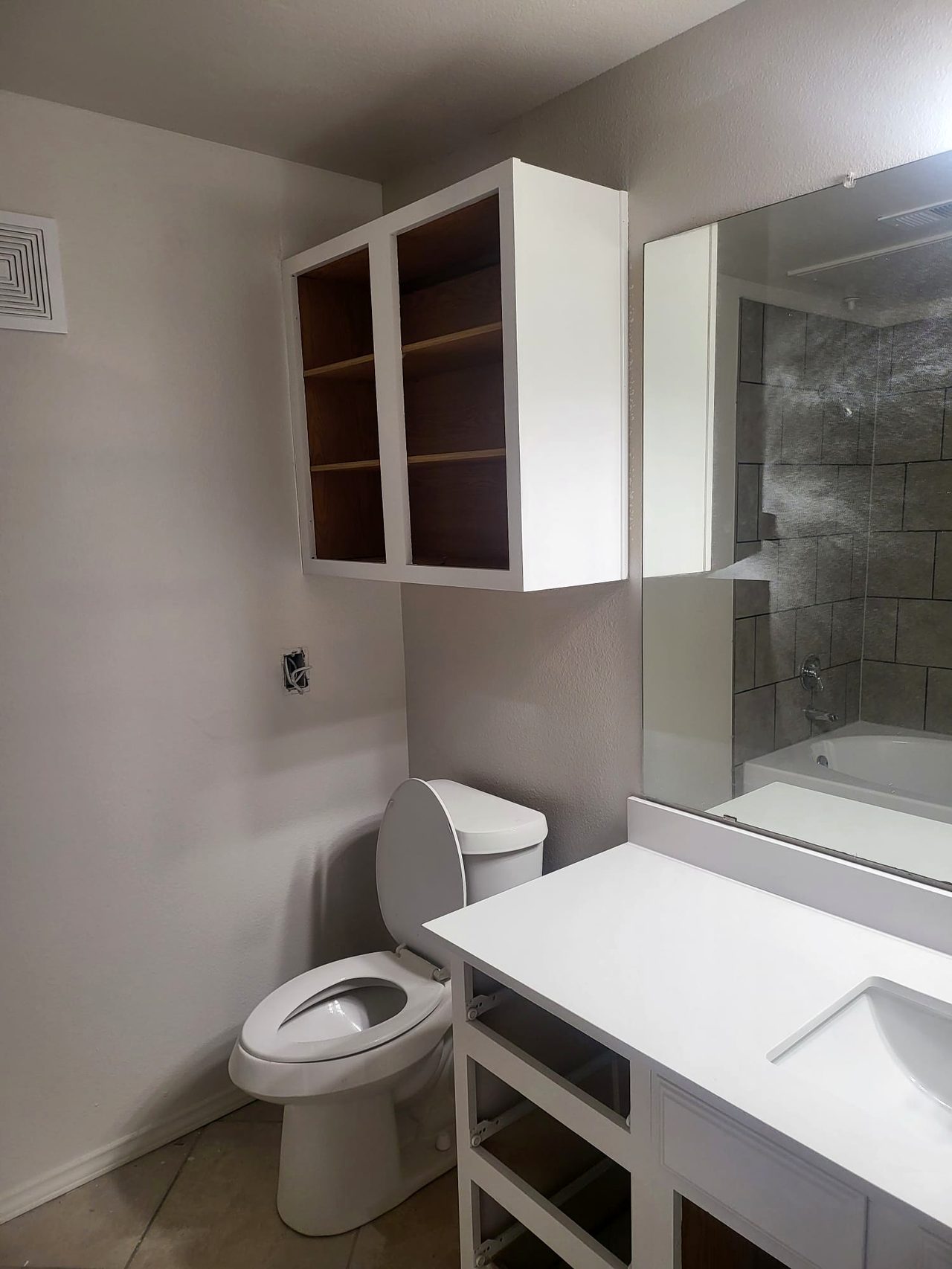 Finished bathroom with white vanity, tile and fresh paint