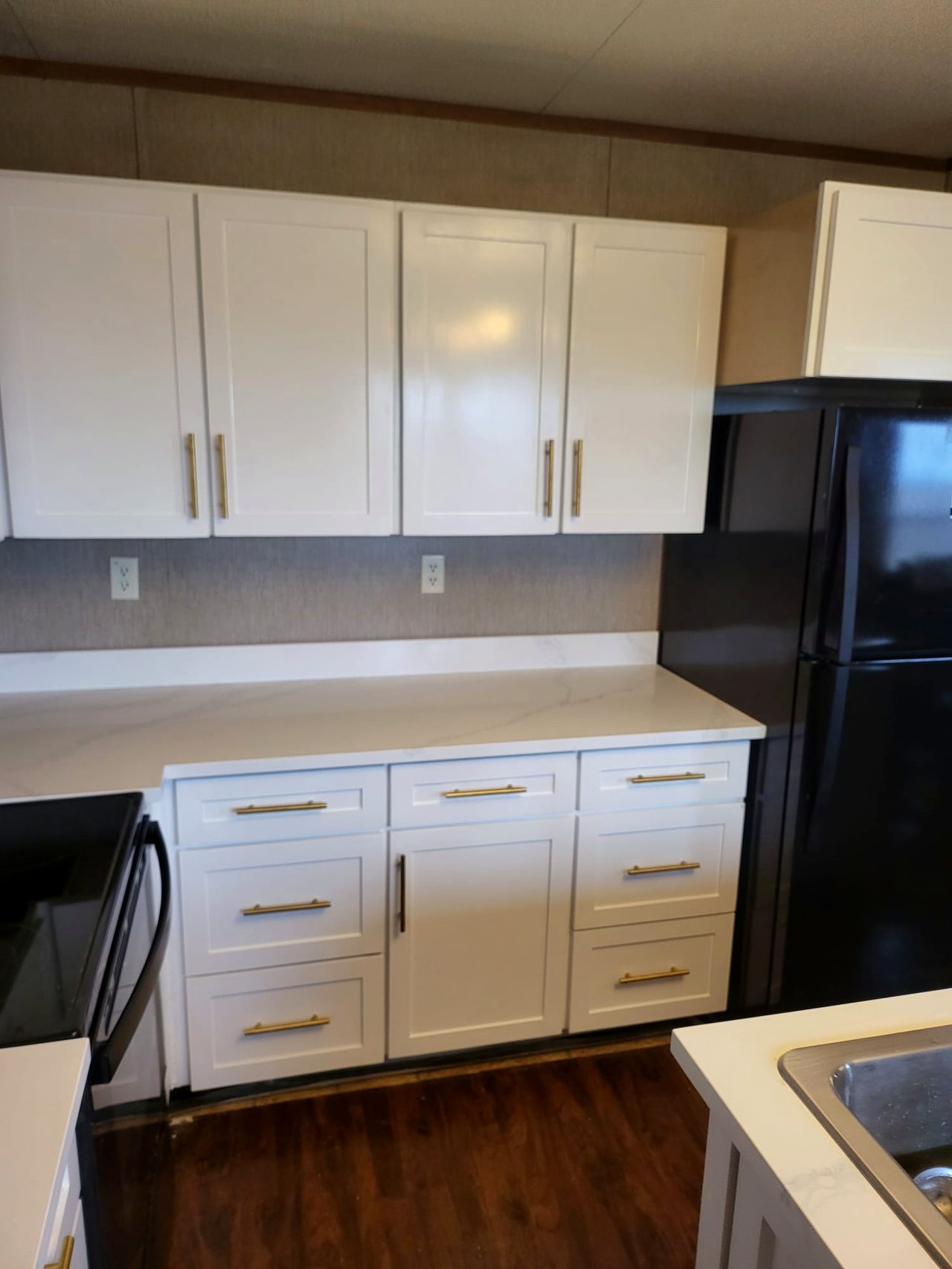 Custom white shaker cabinets with brass hardware and quartz counters