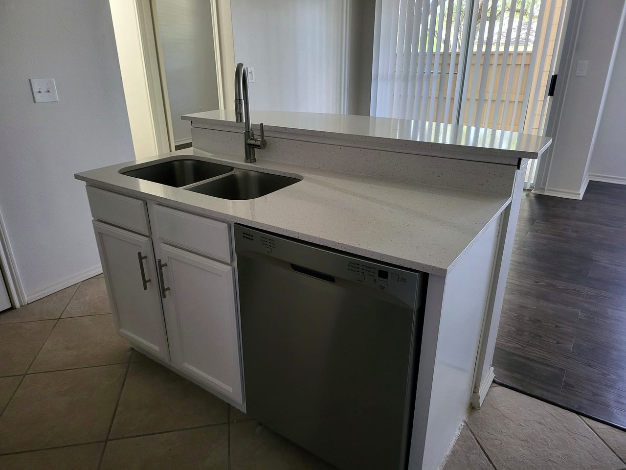 White shaker kitchen with quartz island and wood floor by Alex Rodriguez